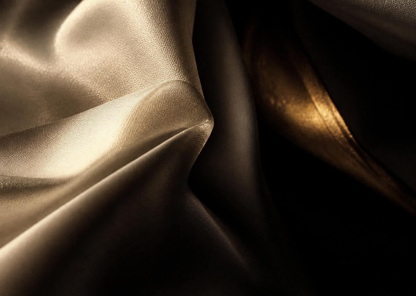 Textura de seda marfim atravessada por um fio de luz champagne
